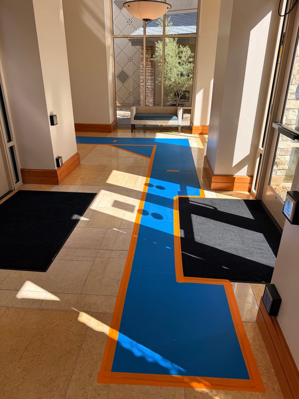 Blue protective runners covering tile floors at a home entryway